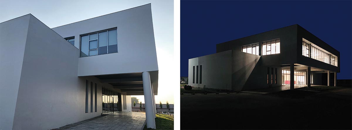 The projecting upper floor protects the wide glass expanse of the entrance lobby