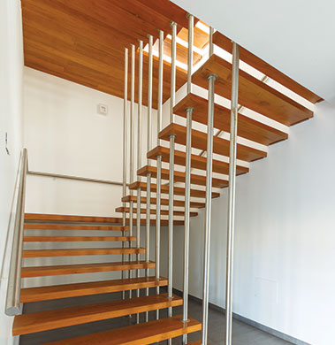 The sleek wooden staircase is embedded with ss pipes as railing